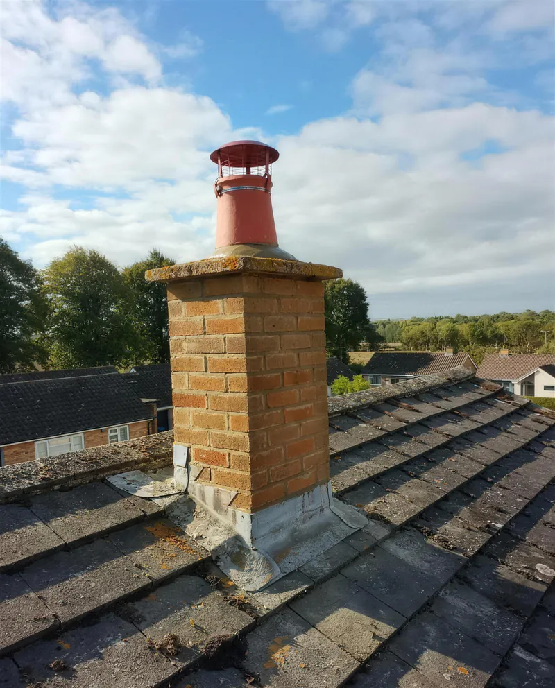 Repointed brick chimney with new lead flashing and a cowl