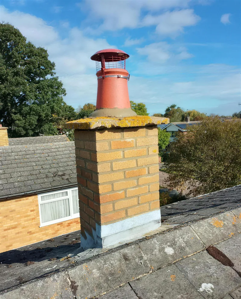 Yellow brick chimney with a terracotta cowl and new lead flashing at the base