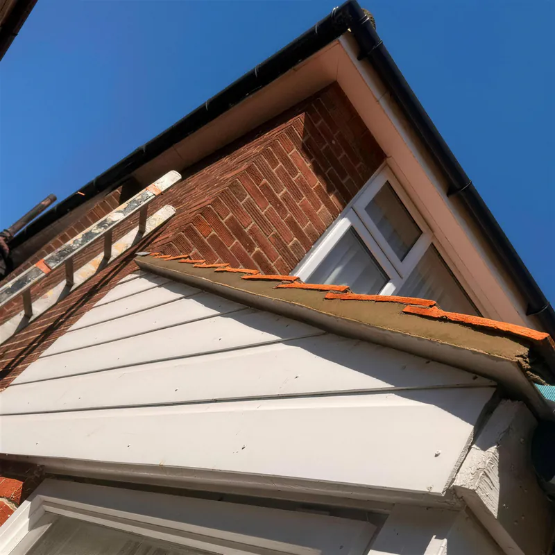 Gable end with new white fascia boards and a tiled roof edge
