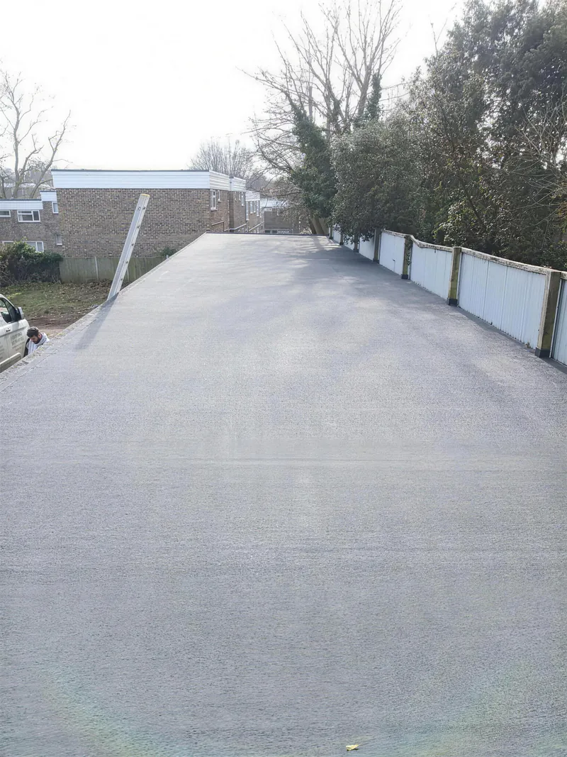 Long new grey flat roof on a single storey building